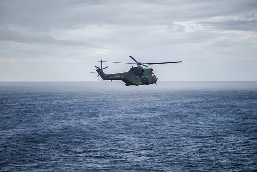 Mediterranean sea, France - January 18, 2012:  French troop transport helicopter Puma flying during windy day over the Mediterranean sea. The mission is to rescue hostages from capture.
