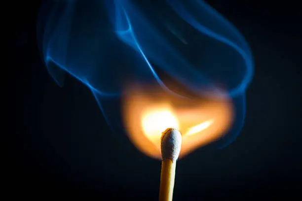 Photo of Lit match with blue smoke