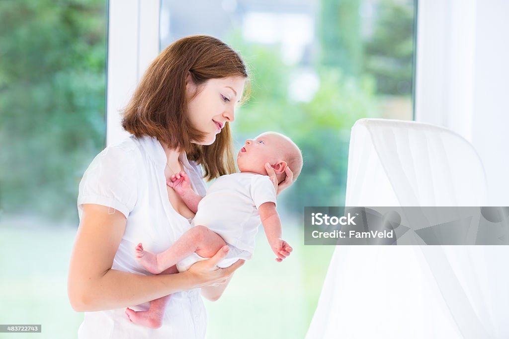 Мать и Новорожденный ребенок на большое окно в белый Питомник - Стоковые фото Балдахин роялти-фри