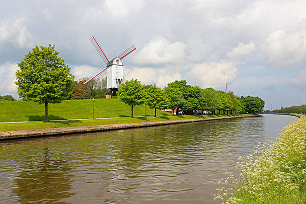 brugge (brugia) wiatraki z canal i kwiaty - belgium bruges windmill europe zdjęcia i obrazy z banku zdjęć