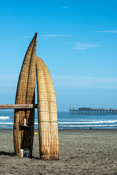 Traditional Reed Boats (Caballitos de Totora), Pimentel, Peru Traditional Peruvian small Reed Boats (Caballitos de Totora), straw boats still used by local fishermens in Peru. On the background – Famous pier at Pimentel trujillo peru stock pictures, royalty-free photos & images