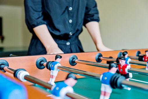 Young asian woman playing foosball.