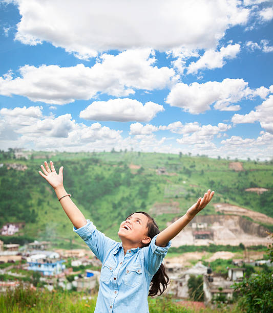 похвала! индийская девочка дает спасибо, как она поднимает руки вверх. - serene people tranquil scene child god стоковые фото и изображения