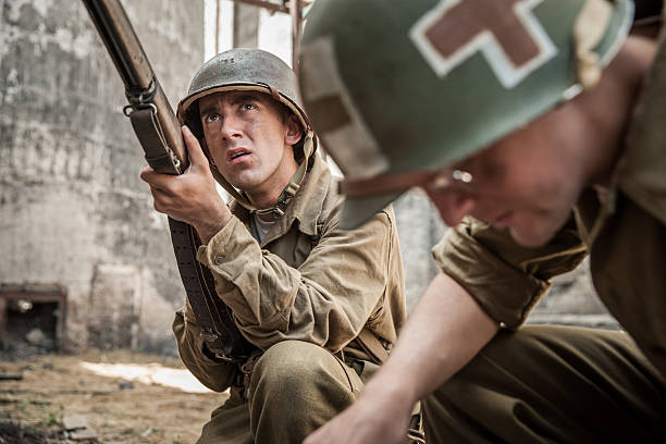 istock WWII Infantry Soldier Guards Medic Administering First Aid to Fa 483731386