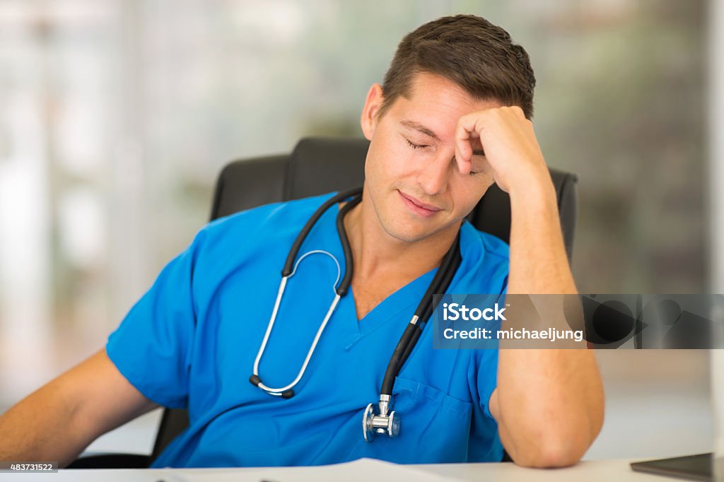 tired medical worker tired medical worker sitting in office 2015 Stock Photo