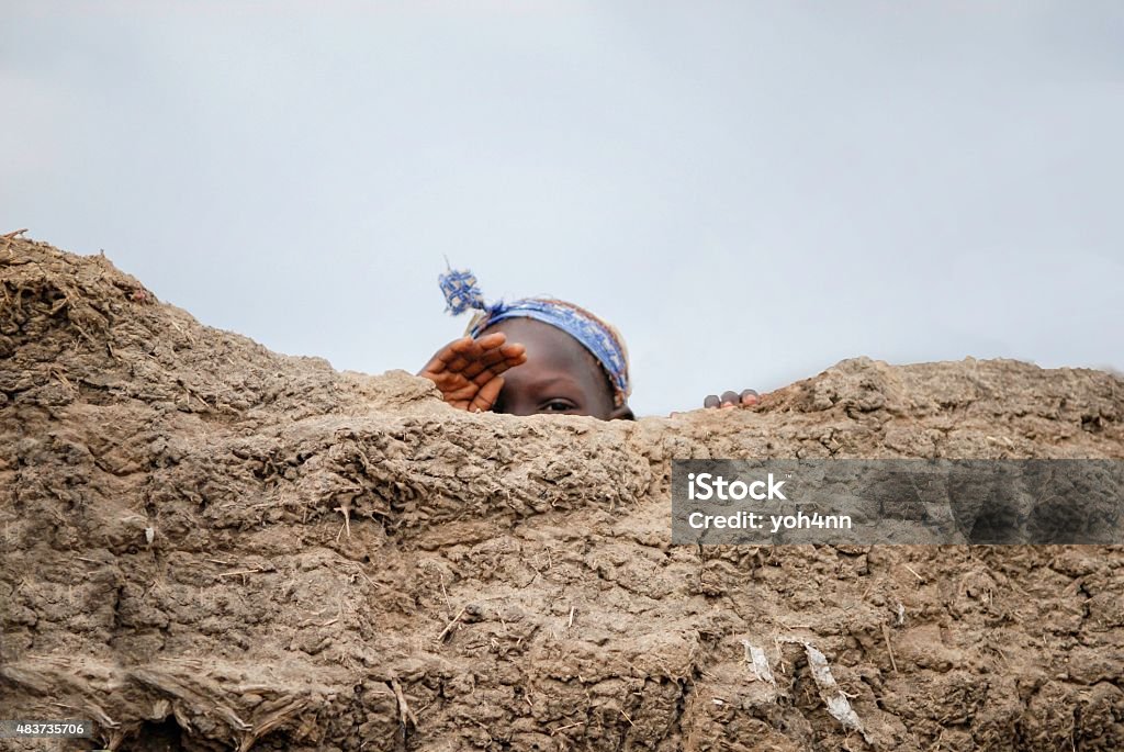 African child Terrified african child hiding behind the wall. War Stock Photo