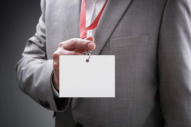 Businessman holding blank ID badge Businessman at an exhibition or conference showing a blank security identity name card on a lanyard celebrity endorsements stock pictures, royalty-free photos & images