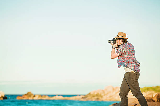 istock Young photographer taking photos at the beach 483744618