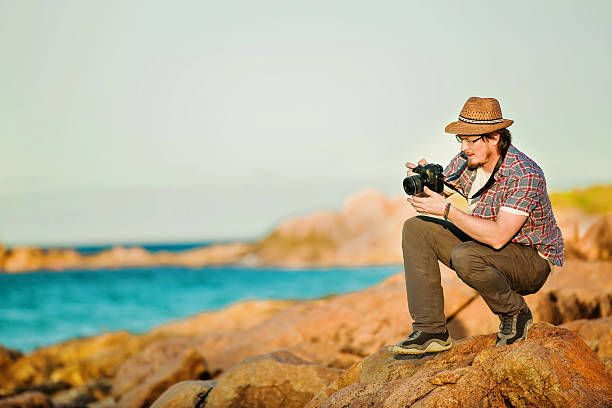 istock Young photographer taking photos at the beach 483744620