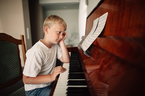 little funny boy plays piano at home
