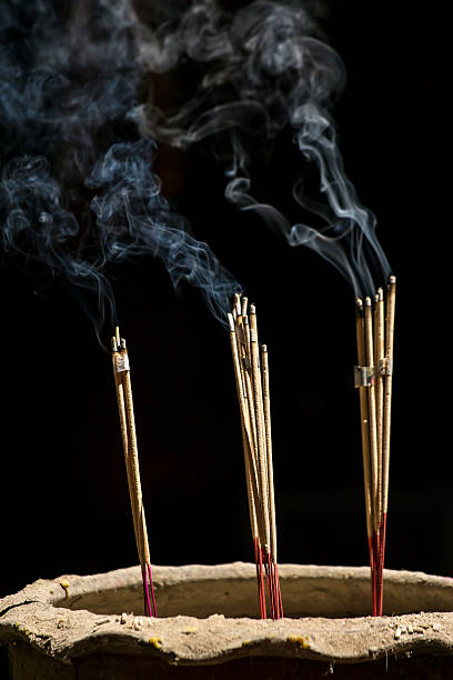 istock Incense sticks with smoke against black background 483747099