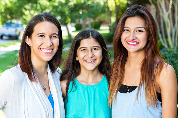 istock Beautiful Hispanic sisters standing outdoors, smiling at camera 483747698