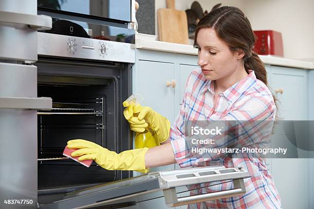 Fed Up Woman Cleaning Oven At Home Stock Photo - Download Image Now - 2015, 30-39 Years, Adult