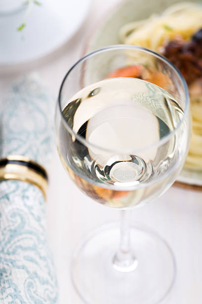 istock Glass of white wine with seafood pasta 483748436