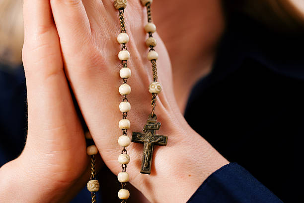 istock Woman praying with rosary to God 483749333