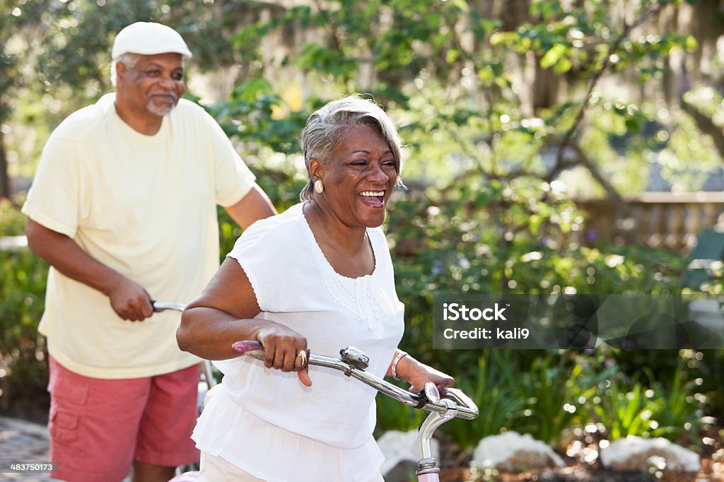 Senior pareja afroamericana ciclismo de bicicletas - Foto de stock de Andar en bicicleta libre de derechos