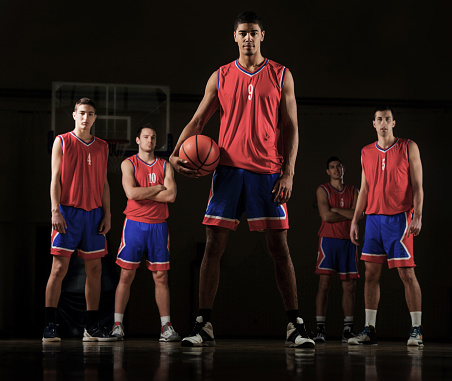 Basketball players standing and looking at the camera.   