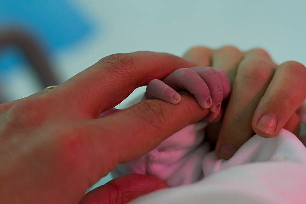 istock newborn grabs his father's finger 483752935