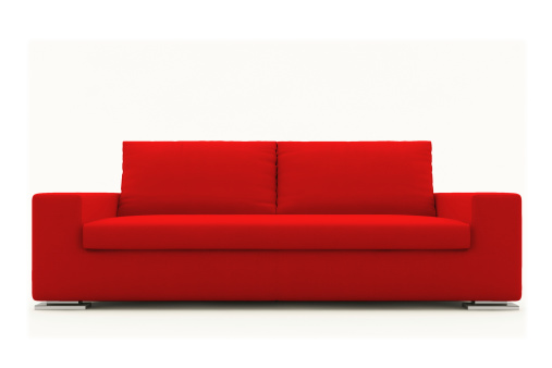Modern red sofa isolated on white neutral background.