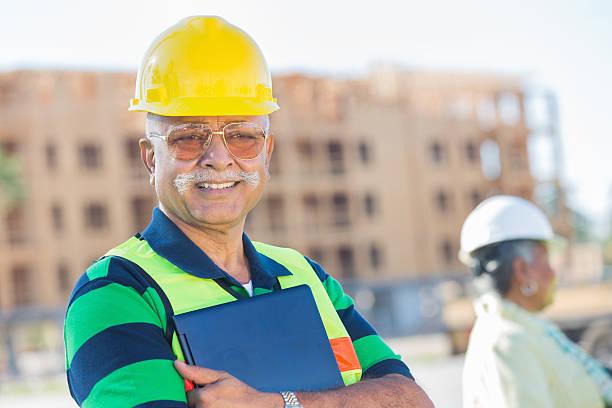 istock Happy man with hard hat on at contruction site 483753529