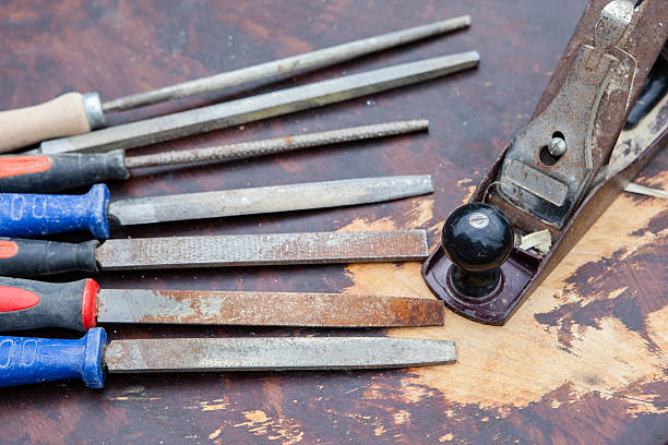 istock Used chisels and a plane on a dark wooden table 483767766