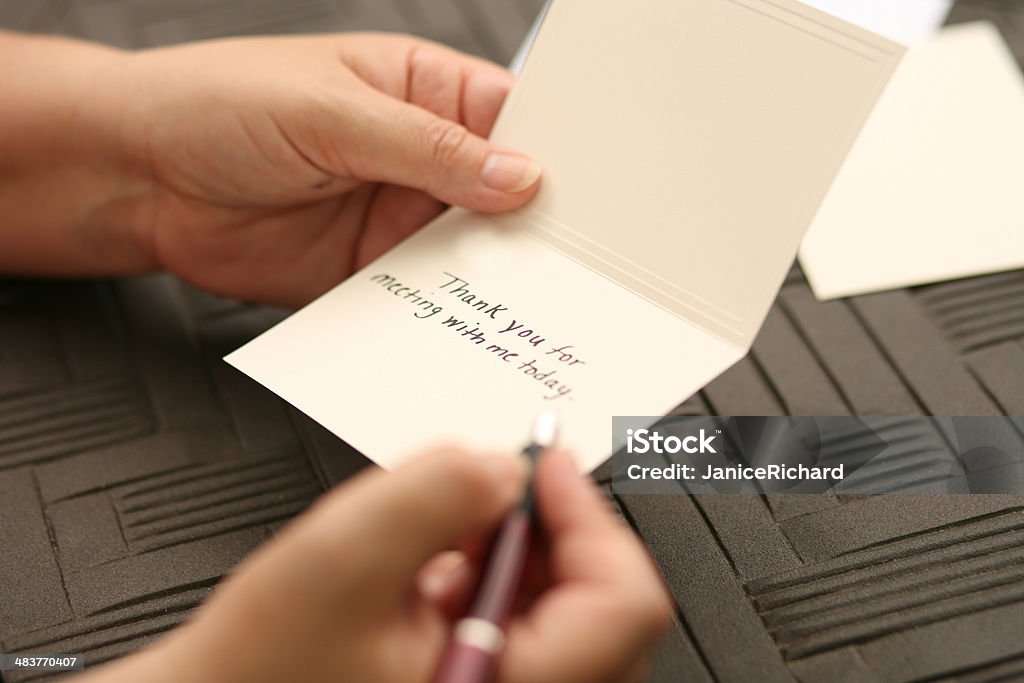 Hand Written Thank You Note Female hands writing a thank you note. Greeting Card Stock Photo