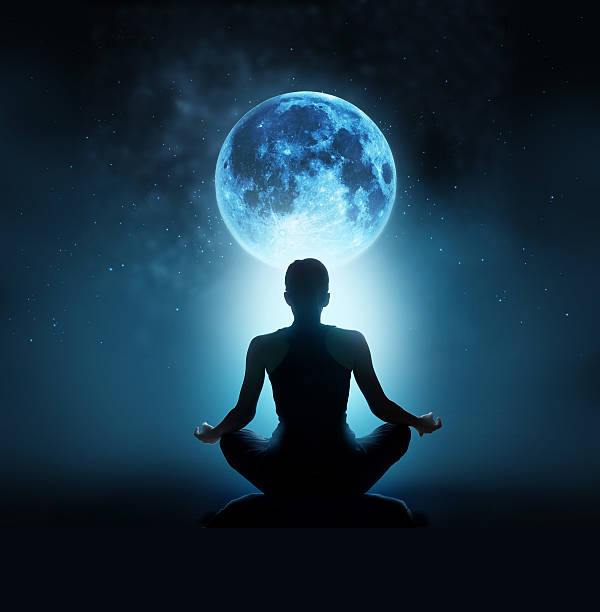 Woman meditating under full moon