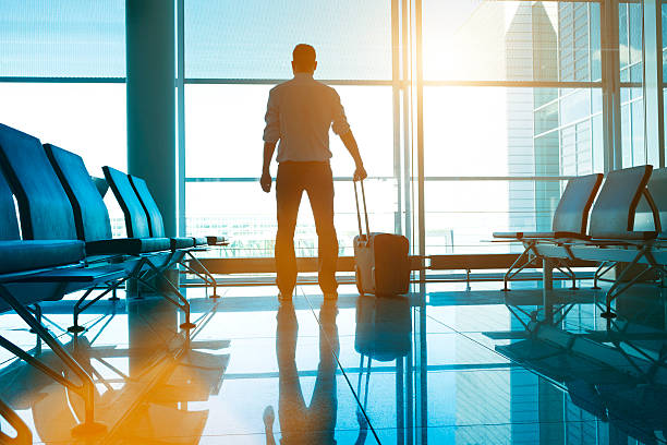 istock Man stands in airport with suitcase waiting for his plane 483775036