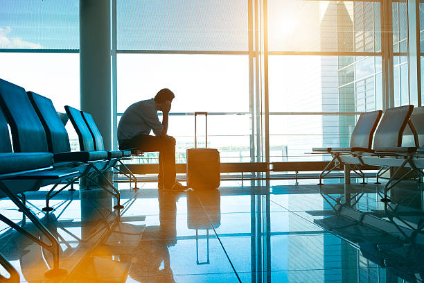 istock Lonesome passenger sits in empty airport waiting for his flight 483775078