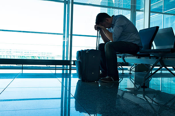 istock Delayed plane makes tired man wait in airport with suitcase 483775082