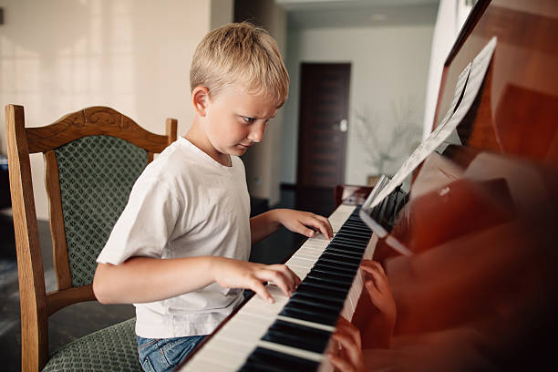 istock little happy boy plays piano 483777740