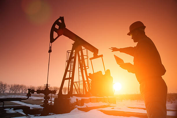 Silhouette of a oil drill worker stock photo