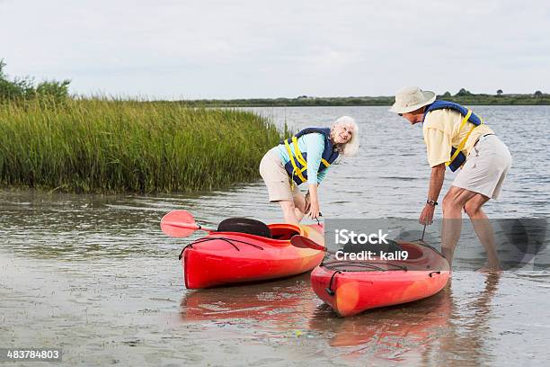 Senior Couple Putting Kayaks Into Water Stock Photo - Download Image Now - Kayaking, Kayak, Mature Adult