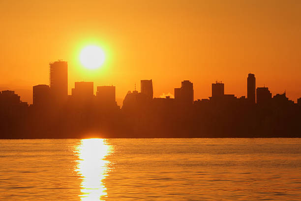 Vancouver Skyline Sunrise, English Bay Sunrise over downtown Vancouver from the south side of English Bay. British Columbia, Canada. beach english bay vancouver skyline stock pictures, royalty-free photos & images