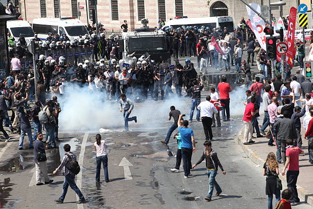 Workers Day in Istanbul Istanbul, Turkey - May1, 2013: The demonstrators who are against to prohibition of 1 May celebration were arrested by the police on May 1,2013 in Istanbul,Turkey police tear gas stock pictures, royalty-free photos & images