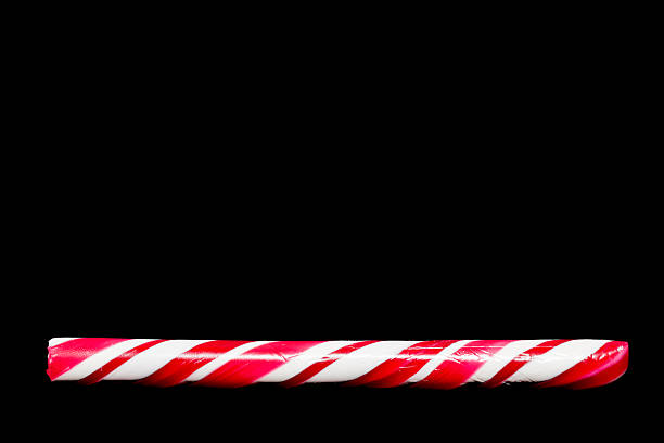 Candy Cane Christmas candy cane on a dark surfaceChristmas candy cane on a dark surface candy peppermint christmas mint stock pictures, royalty-free photos & images