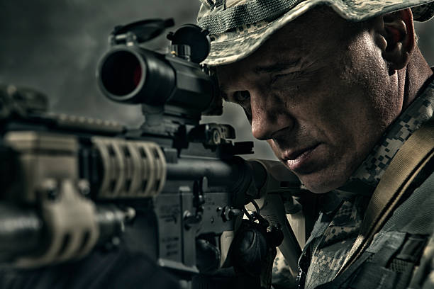Military Sniper prepares to take a shot. This stock image has a horizontal composition.