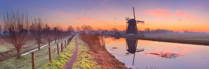 A traditional Dutch windmill at sunrise. A seamlessly stiched panoramic image.