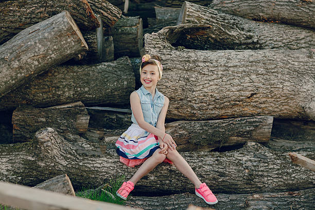 istock beautiful little girl sitting on trees 483794630