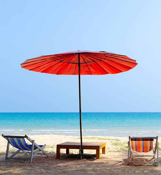 istock Beach chair and red umbrella on the beach 483794974