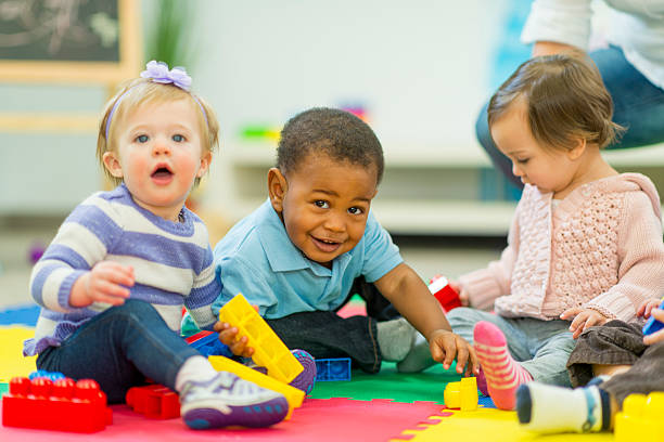 Babies Playing Diverse group of babies playing. preschool building photos stock pictures, royalty-free photos & images