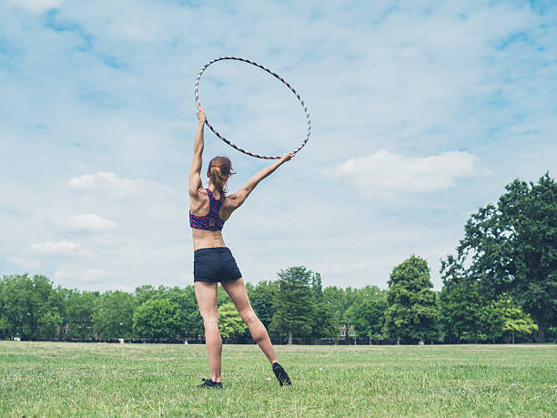 istock Woman standing in park with hula hoop 483798596