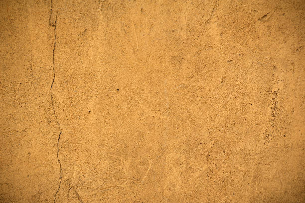 istock Texture of old wall covered with yellow stucco 483799670