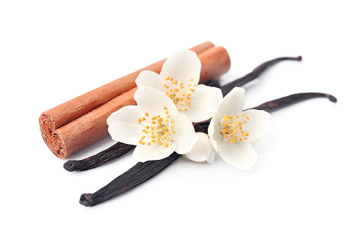 Vanilla sticks and cinnamon with flowers on white backgrounds.