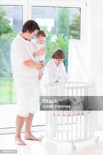 Father And His Kids Next To Crib With Newborn Baby Stock Photo - Download Image Now - Adult, Animal Nest, Baby - Human Age