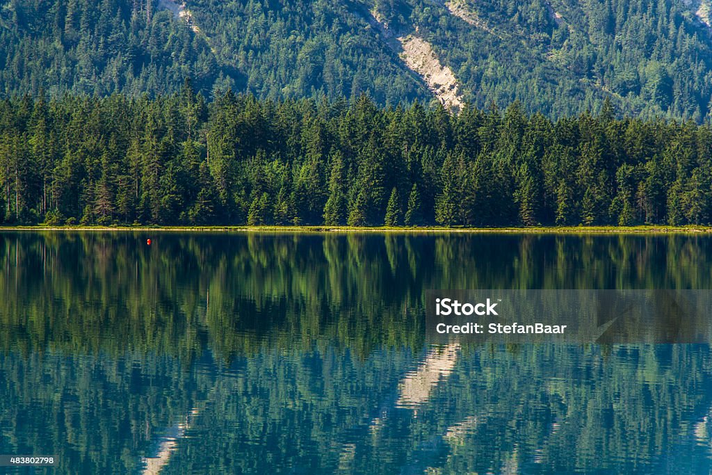 Plansee zoomed A warm summer morning at the Plansee in northern Austria. The Lake reflects the imagery of the mountain range very clearly. 2015 Stock Photo
