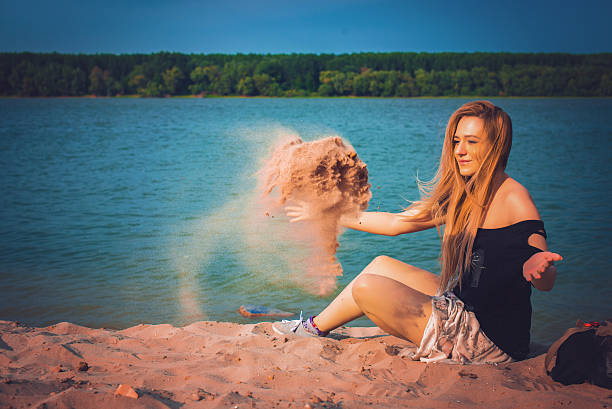 Young female friends covered in colored powder having fun at the beach