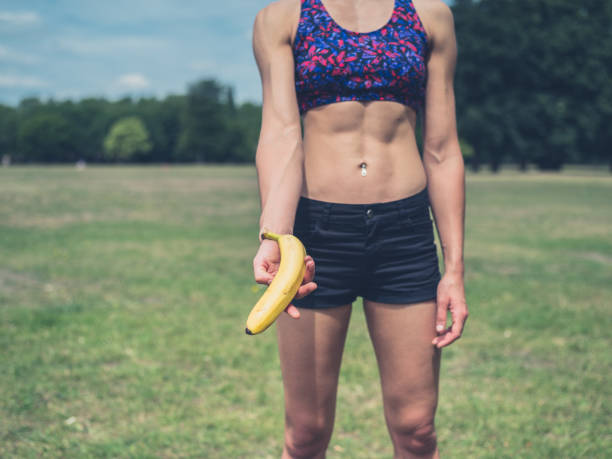 istock Fit woman offering banana 483804300