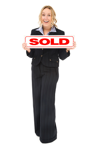 Photo of a real estate agent isolated against white, holding a SOLD sign.