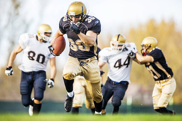 American football. American football players in action on the playing field.    american football ball photos stock pictures, royalty-free photos & images